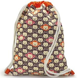 May include: A brown drawstring bag with a white cord. The bag is covered in a pattern of repeating monkey faces in brown, orange, and pink.