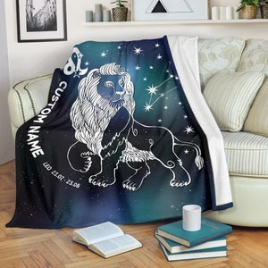 May include: A black and blue fleece throw blanket with a white outline of a lion and the constellation Leo. The blanket has the text "CUSTOM NAME" and "LEO 23.07. - 23.08."