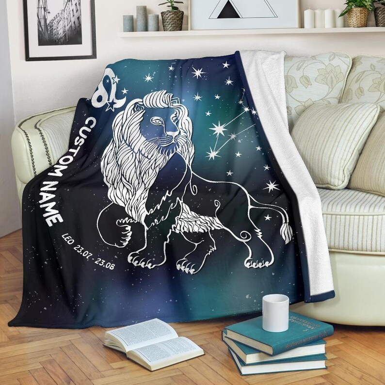 May include: A black and blue fleece throw blanket with a white outline of a lion and the constellation Leo. The blanket has the text "CUSTOM NAME" and "LEO 23.07. - 23.08."