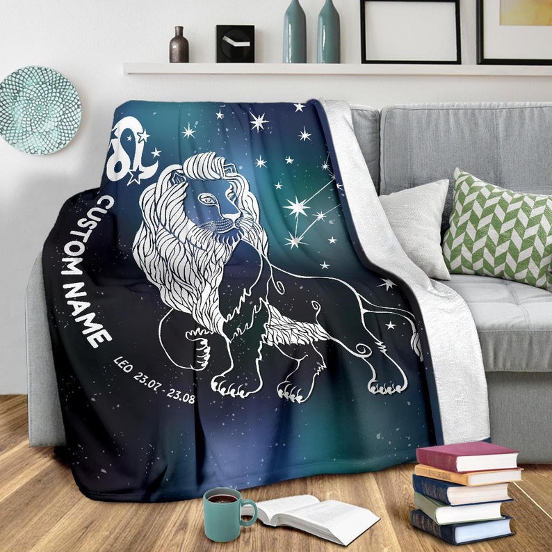 May include: A soft, blue and green throw blanket with a white outline of a lion and stars. The text "CUSTOM NAME" and "LEO 23.07 - 23.08" is printed on the blanket.