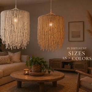 May include: Two cylindrical pendant lights, one off-white and one beige, made from woven material. The lights hang from the ceiling. The text "IN DIFFERENT SIZES AND COLORS" is displayed. The room is decorated in neutral tones.