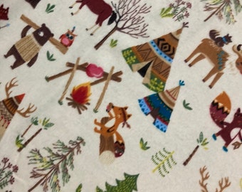 May include: A white fabric with a repeating pattern of woodland animals, teepees, and trees. The animals include a bear, a fox, a deer, and a moose. The teepees are decorated with geometric patterns in red, blue, and green. The trees are green and brown.
