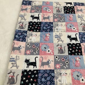 Può includere: Un tessuto patchwork con un motivo ripetitivo di gatti, fiori e il testo "I Meow Paris". Il tessuto è in tonalità di rosa, blu, grigio e nero.