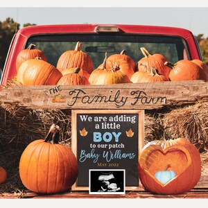 Pode incluir: Uma cena de outono com uma cama de caminhão vermelha cheia de abóboras laranja, fardos de feno e uma placa de madeira que diz "The Family Farm". Um quadro-negro anuncia um menino, "Baby Williams MAY 2022". Uma abóbora é esculpida em forma de coração.