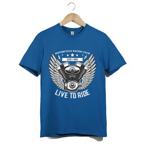 Pode incluir: Uma t-shirt azul-real de manga curta com um gráfico branco de um motor de motocicleta com asas. O texto diz MOTORCYCLE RACING CLUB, ESTD 1995 e LIVE TO RIDE. O design inclui três estrelas e detalhes de relâmpagos.