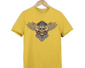 May include: A mustard yellow short-sleeve t-shirt featuring a graphic print of three skulls with wings, ornate black and white scrollwork, and an eye inside a triangle symbol centered on the chest, displayed on a wooden clothes hanger.