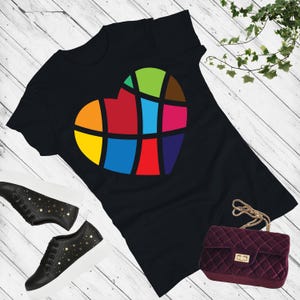 Könnte beinhalten: Ein schwarzes T-Shirt mit einem bunten herzförmigen Design. Das Herz besteht aus verschiedenen farbigen Quadraten und ist schwarz umrandet.
