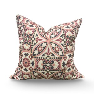 May include: Decorative throw pillow with a detailed floral pattern in shades of burgundy, black, cream, and pink. The pillow features a symmetrical design with stylized flowers and geometric shapes, perfect for adding a touch of elegance to any room.