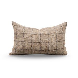 May include: Rectangular decorative pillow with a woven beige fabric and a dark brown plaid pattern. The pillow has a soft, textured appearance and is designed for home decor. The pillow is approximately 20 inches long.
