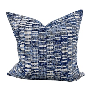 May include: A blue and white patterned throw pillow with a geometric design. The pillow is made of a soft, textured fabric.