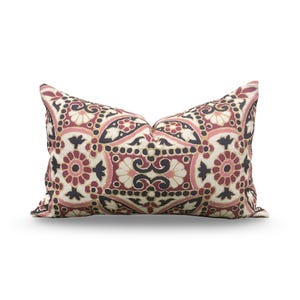 May include: Rectangular decorative pillow with a detailed floral pattern. The pillow features a cream background with burgundy, black, and pink floral and geometric designs. The pillow is a soft, comfortable accent piece for a bed or sofa.