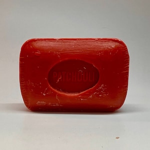 May include: A red bar of soap with the word "PATCHOULI" embossed on it.
