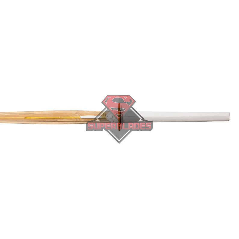 May include: A close-up of a wooden table tennis bat with a white rubber surface. The bat has a yellow stripe running along the edge.