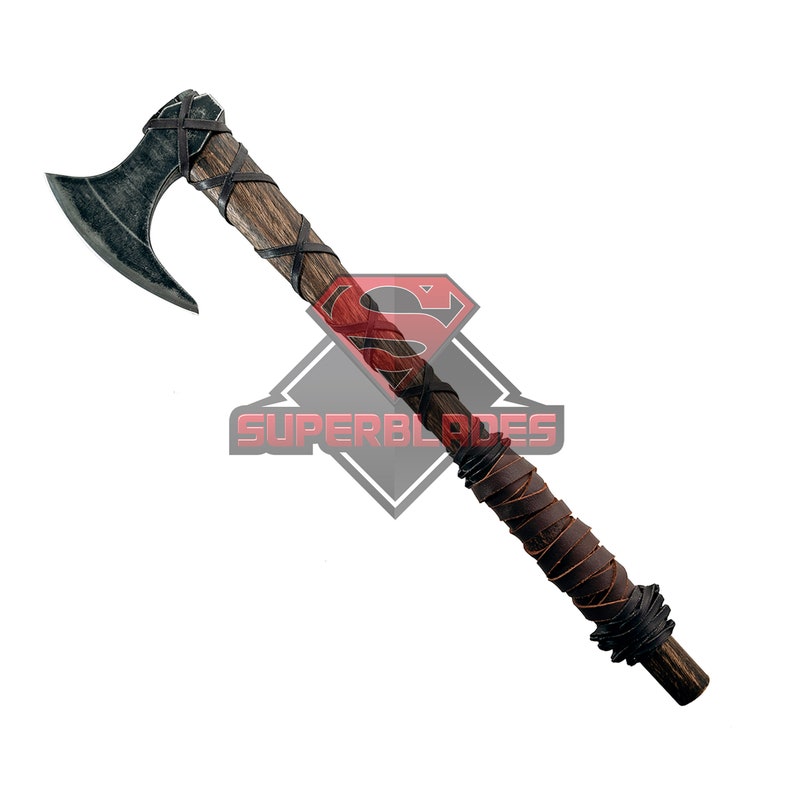 May include: A black and silver axe with a wooden handle wrapped in brown leather. The axe has a curved blade and a leather strap around the handle.
