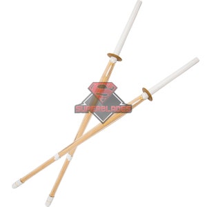 May include: Two wooden practice swords with white padded tips, crossed over each other. The swords are made of bamboo and have a natural wood finish.