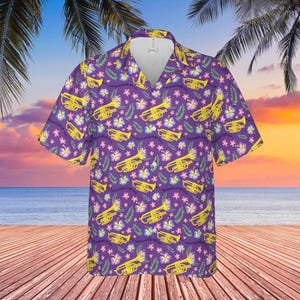 May include: A purple short-sleeved button-up shirt with a tropical print featuring yellow trumpets and pink flowers.