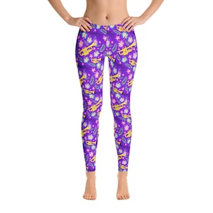 May include: Purple leggings with a floral and trumpet pattern. The flowers are pink, yellow, and white. The trumpets are gold.