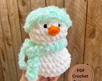 May include: A crochet snowman pattern in PDF format. The snowman is white with a green hat and scarf. The pattern includes instructions for crocheting the snowman.