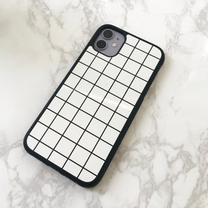 May include: A black phone case with a white grid pattern. The case has a cutout for the camera lens.