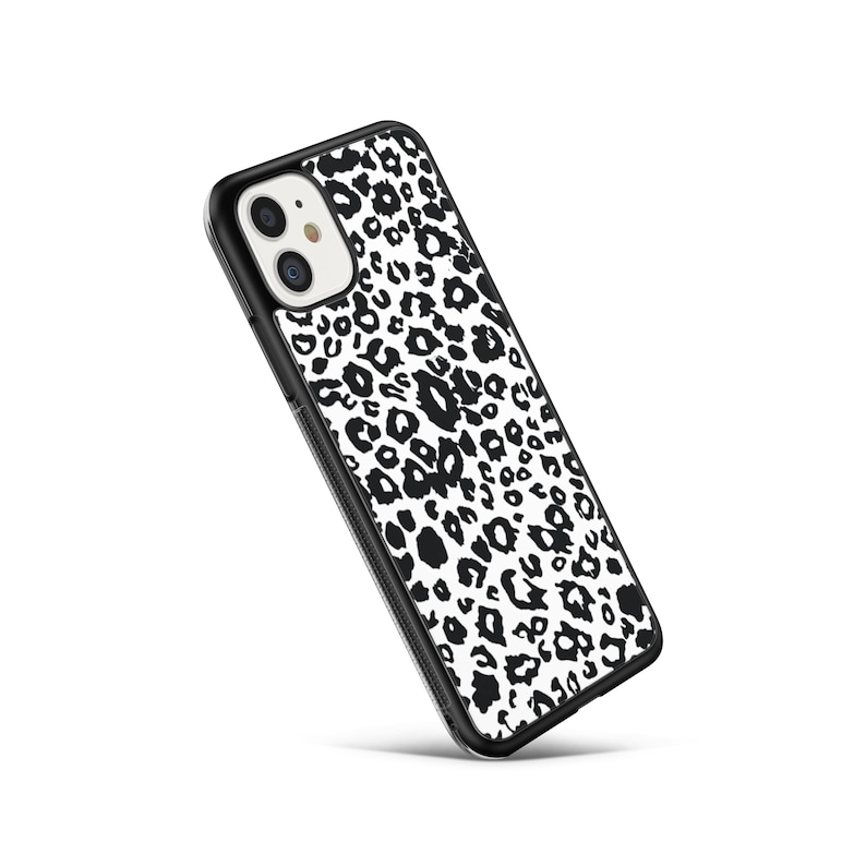 May include: A black phone case with a white and black leopard print design.