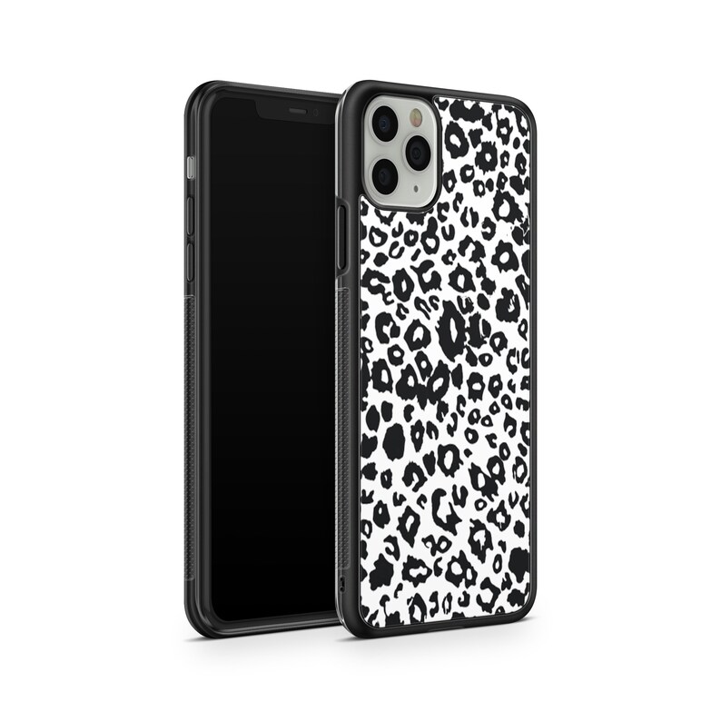 May include: Black and white leopard print phone case for an iPhone. The case has a black border and a clear back.