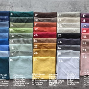 May include: A color chart displaying a variety of fabric swatches. The swatches are arranged in rows and columns, showcasing a wide spectrum of colors, including blues, greens, browns, and pinks. Each swatch is labeled with a number and color name.