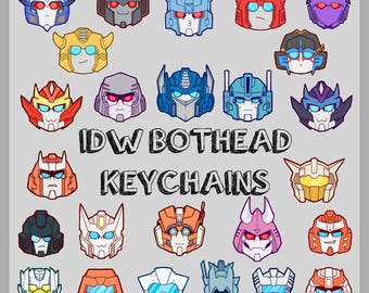 May include: A collection of colorful cartoon robot head designs, each with unique features and expressions. The text "IDW BOTHEAD KEYCHAINS" is displayed below the robot heads, suggesting these are keychains.