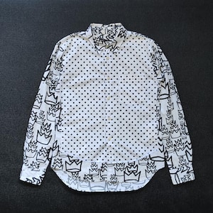 May include: White long-sleeve button-down shirt with a black polka dot pattern and a black crown design on the sleeves and bottom hem.