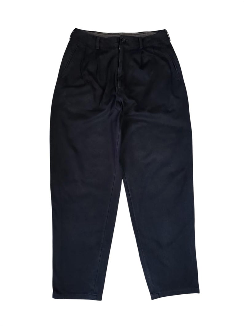 Puede incluir: Pantalones azul marino oscuro con un dise&ntilde;o cl&aacute;sico. Los pantalones tienen cierre de bot&oacute;n y cremallera, trabillas para el cintur&oacute;n y bolsillos delanteros. La tela parece ser un material de peso medio, adecuado para diversas ocasiones.