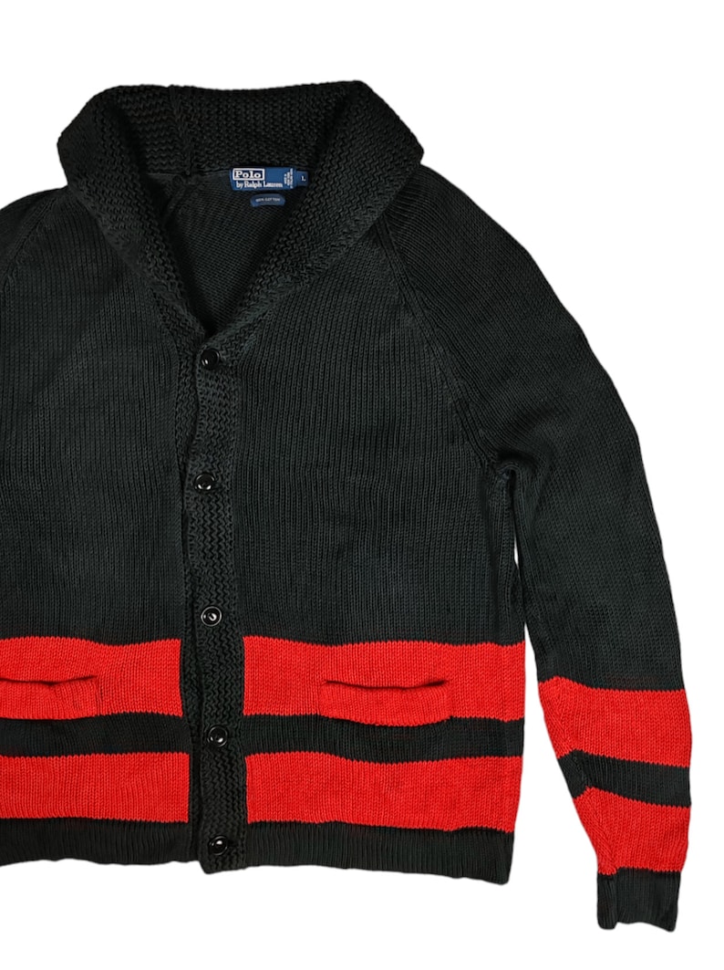 May include: Black cardigan sweater with red stripes and a shawl collar. The sweater has two pockets and buttons down the front. The label reads "Polo by Ralph Lauren" and "L".