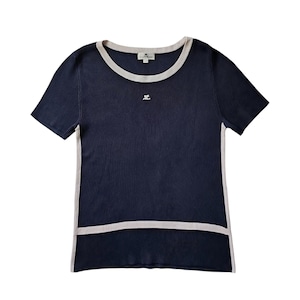 May include: A navy blue short-sleeved ribbed knit top featuring a round neckline with beige trim, matching beige side panels, and a horizontal beige band near the hem. A small white logo is embroidered on the chest, and a brand label is at the neck.