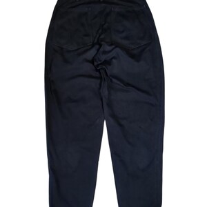 Puede incluir: Pantalones azul marino oscuro con dos bolsillos traseros. Los pantalones tienen un dise&ntilde;o cl&aacute;sico de pierna recta y cierre de bot&oacute;n y cremallera. La tela parece ser un material tejido resistente.