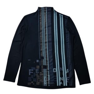 May include: Black long-sleeve shirt with a mock neck. The shirt features a vertical striped design in shades of gray, blue, and brown on the front. The letters "F E N D I" are printed in a pixelated font on the left side, and "DNA" is printed on the right side.