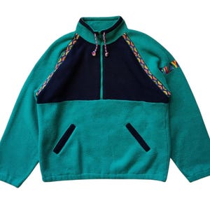 May include: A green fleece pullover with a black panel and colorful trim. The pullover has a zipper closure and a stand-up collar.