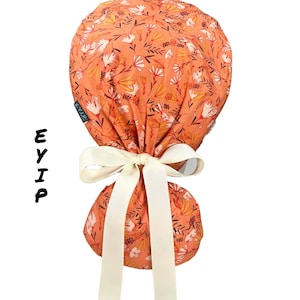 Ponytail scrub cap for women by EYIP, small flowers on peach surgical cap, ivory ribbon & clear buttons