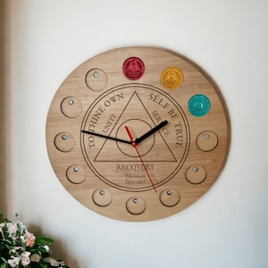 May include: A wooden clock with a circular design featuring a triangle with the words "To Thine Own Self Be True" and "Unity, Service" inscribed inside. The clock face also includes the words "Recovery Elizabeth 28.11.2023".