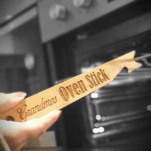 May include: A wooden oven stick with the text "Grandma's Oven Stick" engraved on it.
