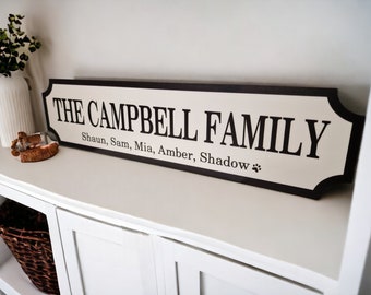 May include: A black and white sign with the text "The Campbell Family" and the names "Shaun, Sam, Mia, Amber, Shadow" with a paw print.