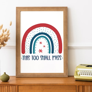 May include: A framed print with a red, blue, and teal rainbow with white stars and the text "This too shall pass".