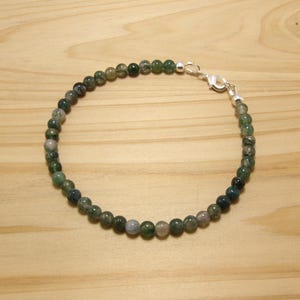 May include: A green and grey agate beaded bracelet with a silver clasp.