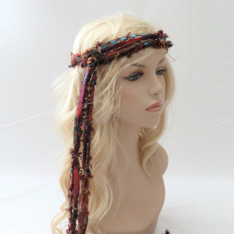 Peut inclure: Un bandeau en tissu tiss&eacute; avec de longues m&egrave;ches color&eacute;es qui pendent. Le bandeau est brun, rouge et bleu avec une touche de turquoise.