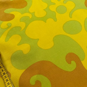 May include: Yellow, green, and brown fabric with a swirling, abstract pattern.