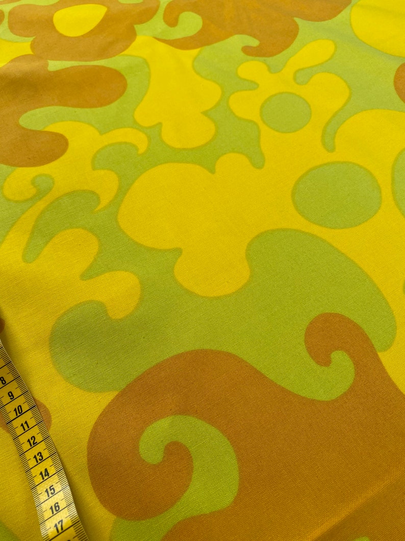 May include: Yellow, green, and brown fabric with a swirling, abstract pattern.