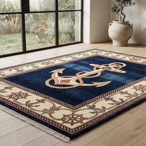 May include: Navy blue rectangular rug featuring a gold anchor design. The rug's border has a cream-coloured pattern of anchors and ship wheels. It is placed on a light wood floor.