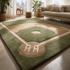 May include: A green and tan baseball field rug with white lines and the letters "AA" in the home plate area. The rug has a soft, plush texture and is designed to resemble a baseball field.
