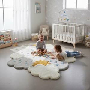 Op de afbeelding: Een kinderkamer met een wolk-vormig tapijt met details van zon en regen. Twee kinderen spelen met houten blokken en een teddybeer. Een witte wieg, een boekenplank en een stoel bevinden zich ook in de kamer.