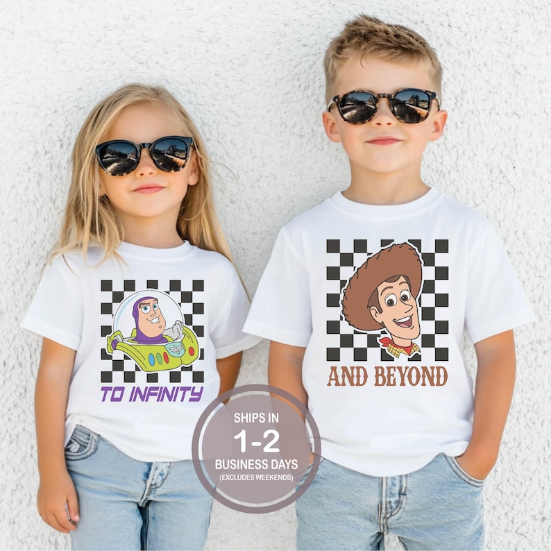 May include: Two children wearing white t-shirts with cartoon character graphics. One shirt features Buzz Lightyear in a spaceship with the text "TO INFINITY". The other shirt has Woody with the text "AND BEYOND". Both shirts have a checkered background.