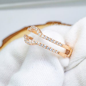 Puede incluir: Un anillo de refuerzo de oro rosa con una doble fila de piedras de circonita c&uacute;bica transparentes.