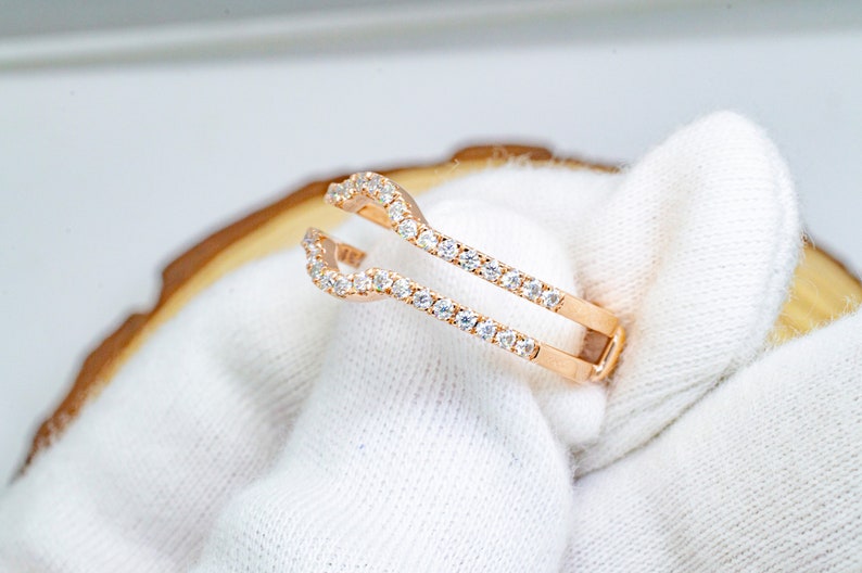 Puede incluir: Un anillo de refuerzo de oro rosa con una doble fila de piedras de circonita c&uacute;bica transparentes.