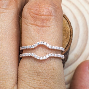 Puede incluir: Una delicada montura de anillo de doble garra con una banda curva engastada con diamantes pav&eacute;. La montura est&aacute; dise&ntilde;ada para sujetar una piedra central, creando un anillo de compromiso hermoso y elegante.
